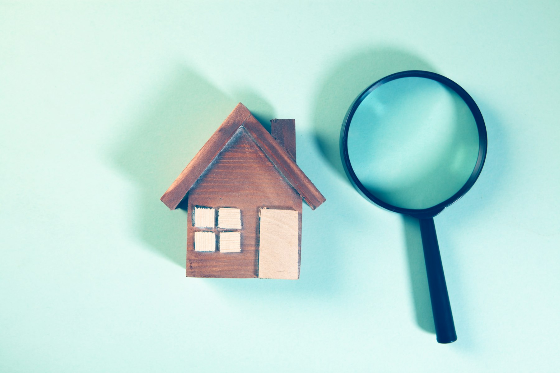 Magnifying glass over a small house model