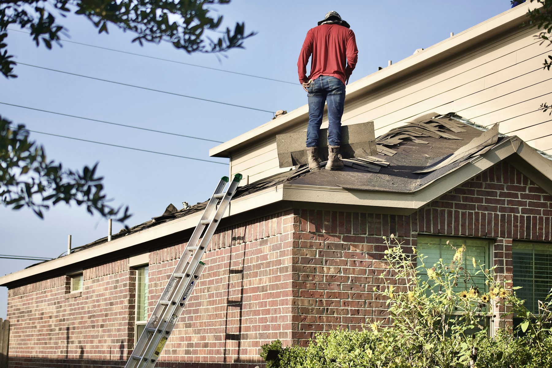 Inspector standing on a roof checking shingles